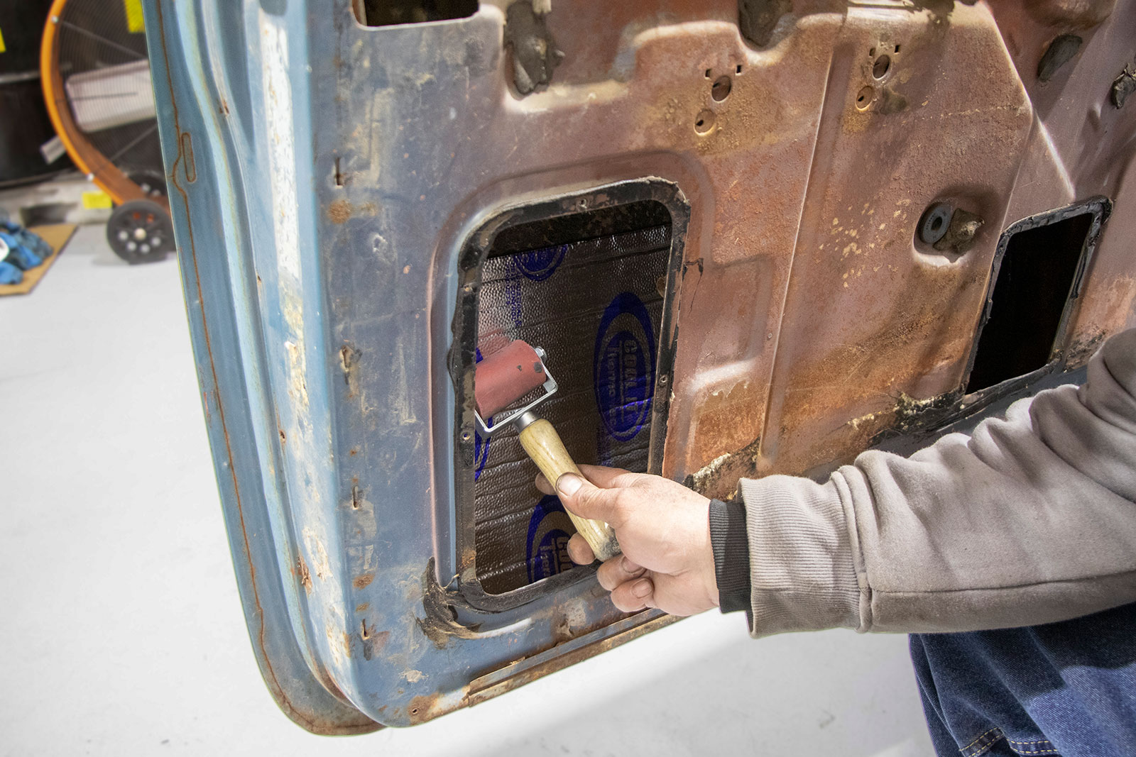 17 Use the roller to press the mat into the door skin doing your best to reach all the edges of the insulation