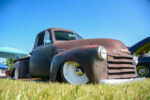 02 Low profile Chevrolet pickup in matte brown exhibiting at a classic car event
