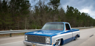 001 The 1982 Chevy truck driving on a highway emphasizing its custom look and low profile