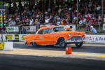 009 Orange 1955 Chevy Bel Air from a low angle highlighting rear and side chrome trim
