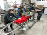 01 Team installing a red engine on the 66 GMC truck frame