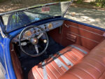 01 Vintage style car interior with upholstered seats and leather wrapped Banjo wheel