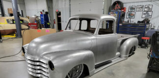 001 A raw metal '51 Chevy truck body undergoing custom restoration in a workshop