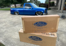 01 Two Vintage Air boxes on display in front of a customized blue 1990s Chevrolet CK 1500