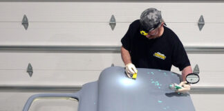 01 Applying body filler to repair pinholes on a primed Chevy K10 door panel during restoration