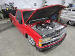 01 Red OBS with open hood showcasing engine modifications in a garage