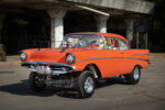 003 1957 Chevy Bel Air gasser in bright orange featuring a prominent front end lift and polished wheels
