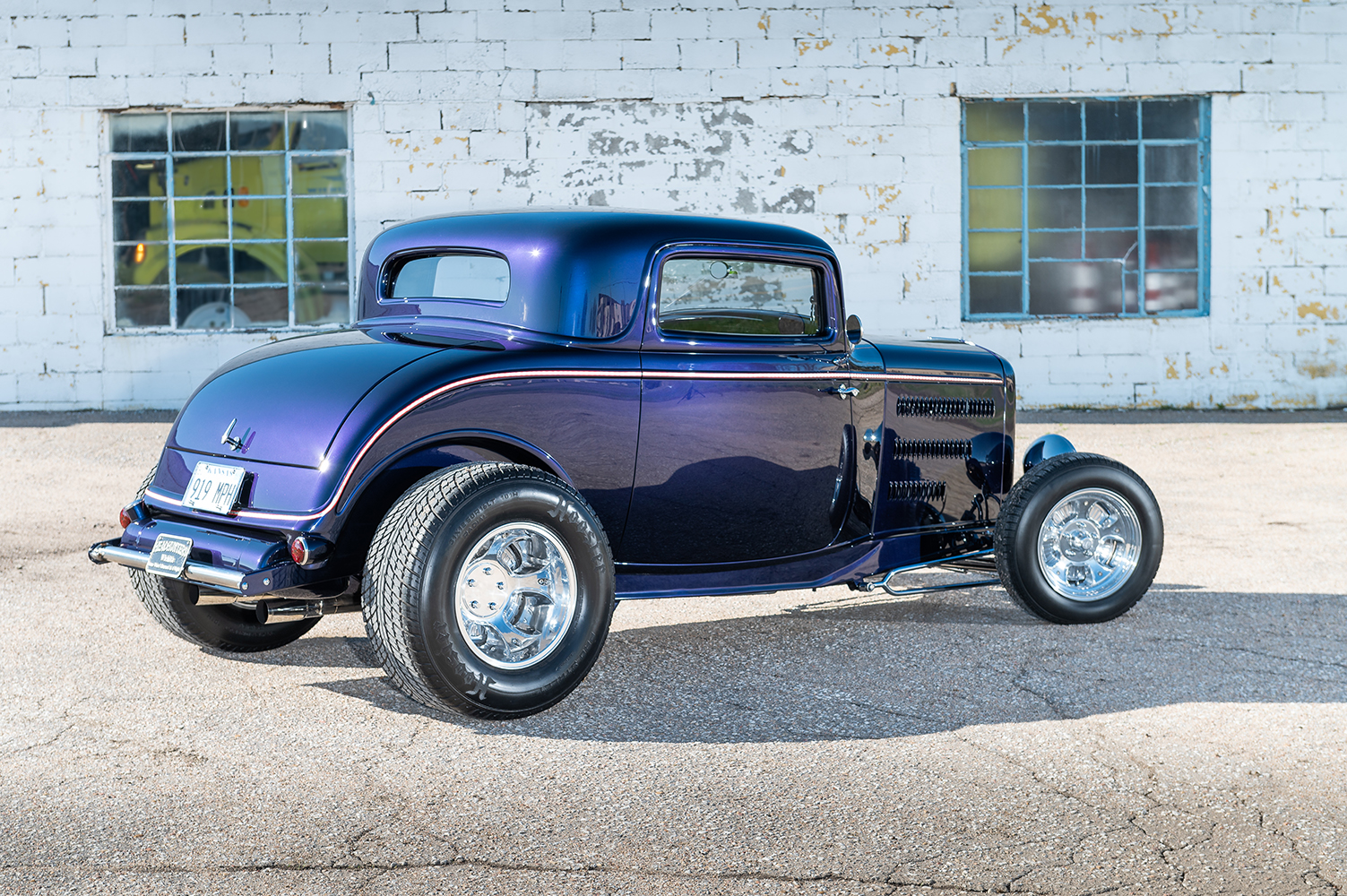 04 Rear view of 1932 Ford Coupe showcasing chrome wheels and sleek deep blue finish