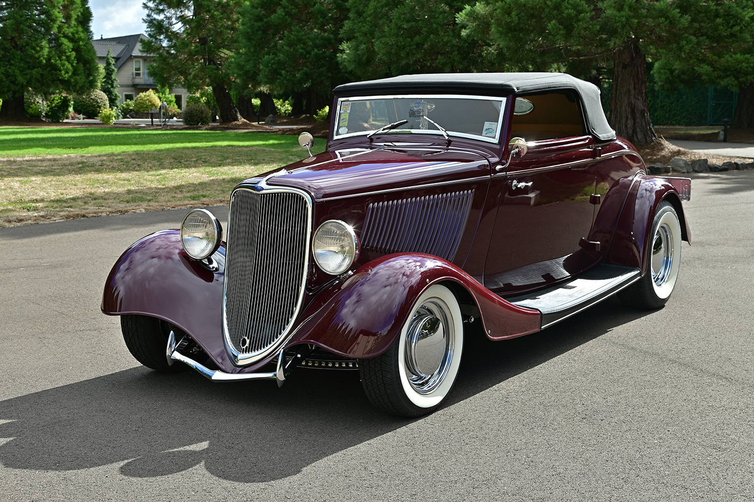 05 1933 Ford Cabriolet front angle featuring Ford V8 emblem chrome grille surround and wide whitewall tires