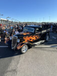 07 Custom 1934 Ford pickup with flame paint job admired by spectators at the truck show