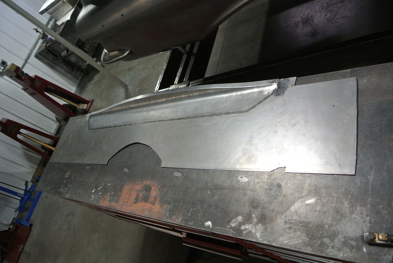 07 Freshly fabricated metal side panel likely a fender or part of the inner structure for the 1959 Chevy