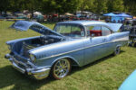 11 1957 Chevrolet Bel Air in sky blue with red interior and chrome wheels showcasing a pristine engine bay at Tri Five Nationals