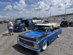 13 Patina styled 1972 Chevrolet C10 with white steel wheels and an accompanying vintage panel truck on display