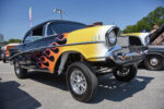 18 1955 Chevrolet drag car “Bad Medicine” in matte black lifting off the starting line with aggressive stance and decals