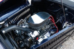 20 Side view of 1932 Ford Coupe's engine featuring Speeding Performance parts and red ignition wiring