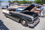 21 1955 Chevrolet Bel Air with a patina finish black body and rusted accents showcasing an open engine bay