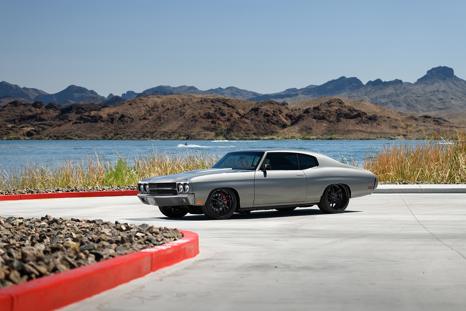 002 1970 Chevy Chevelle by the lakeside showcasing a pristine restoration with modernized styling