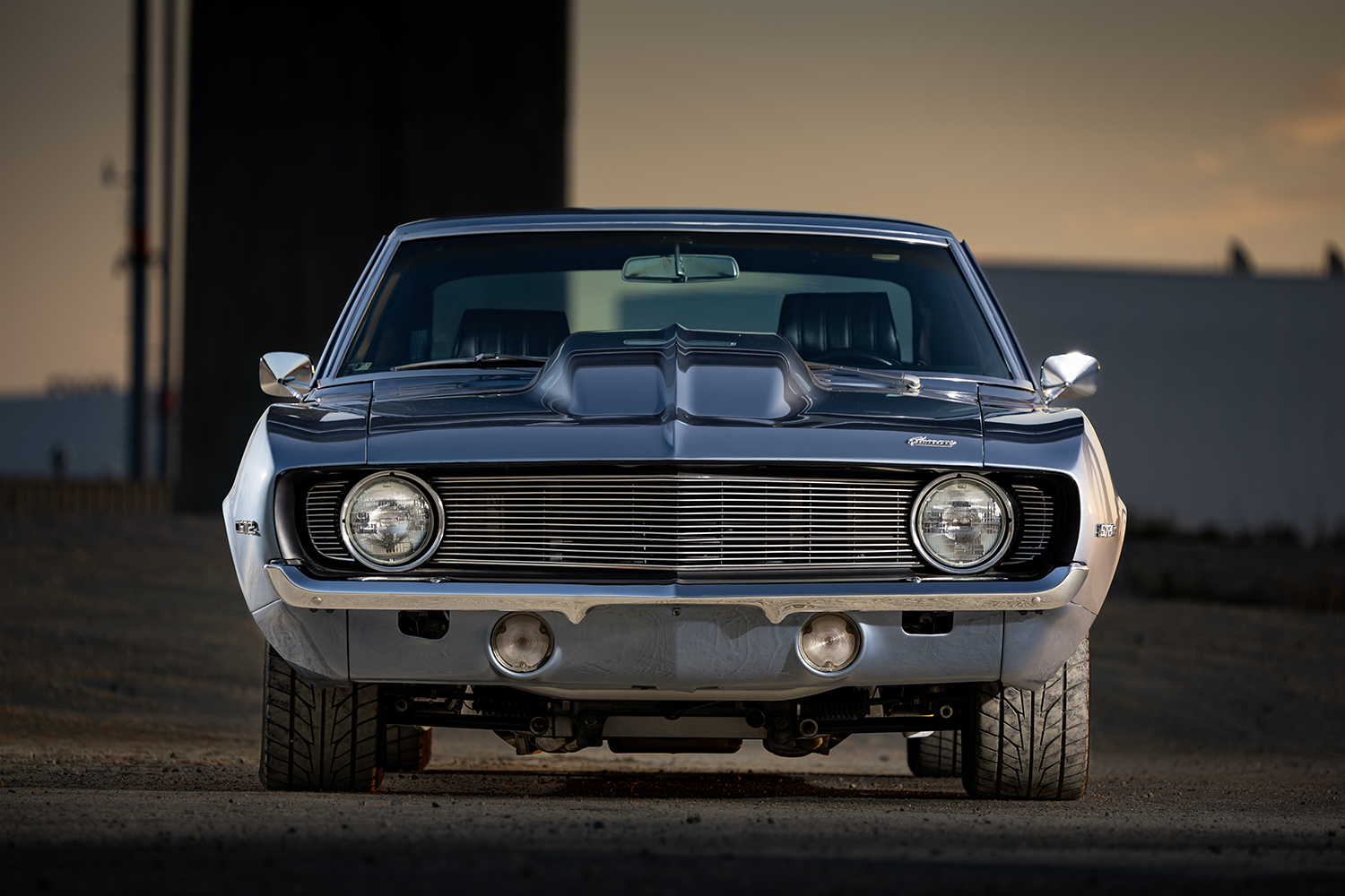005 1969 Camaro under hood reveals a polished Edelbrock equipped engine with braided lines and custom performance upgrades