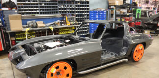 01 C2 Corvette undergoing a custom build with bright orange wheels smooth gray body and side exit exhausts