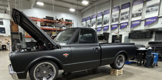01 Chevy C10 truck on wood risers showcasing a matte black finish and open hood for customization