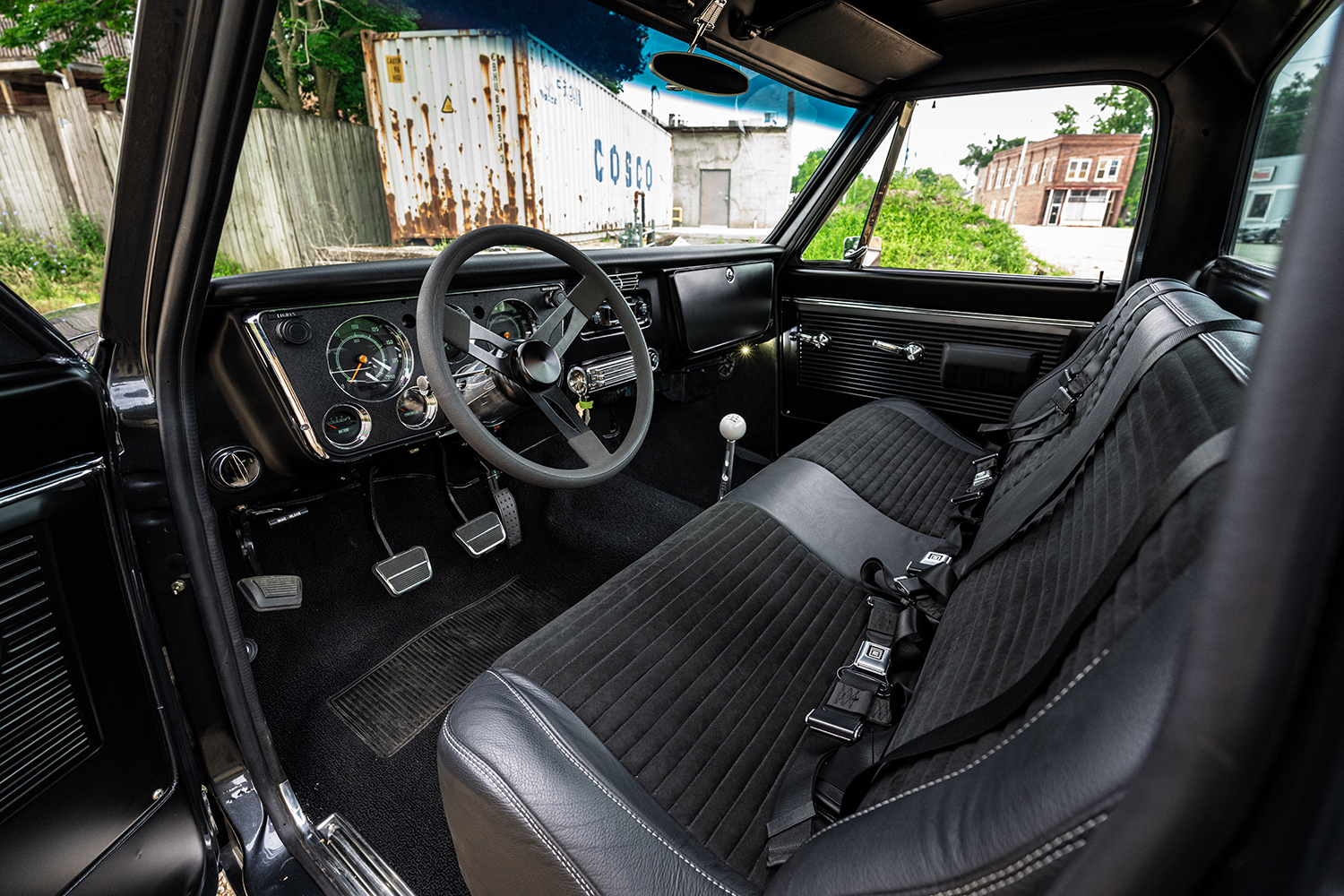 06 1969 Chevy C10 interior with black bench seats retro steering wheel and modern gauges