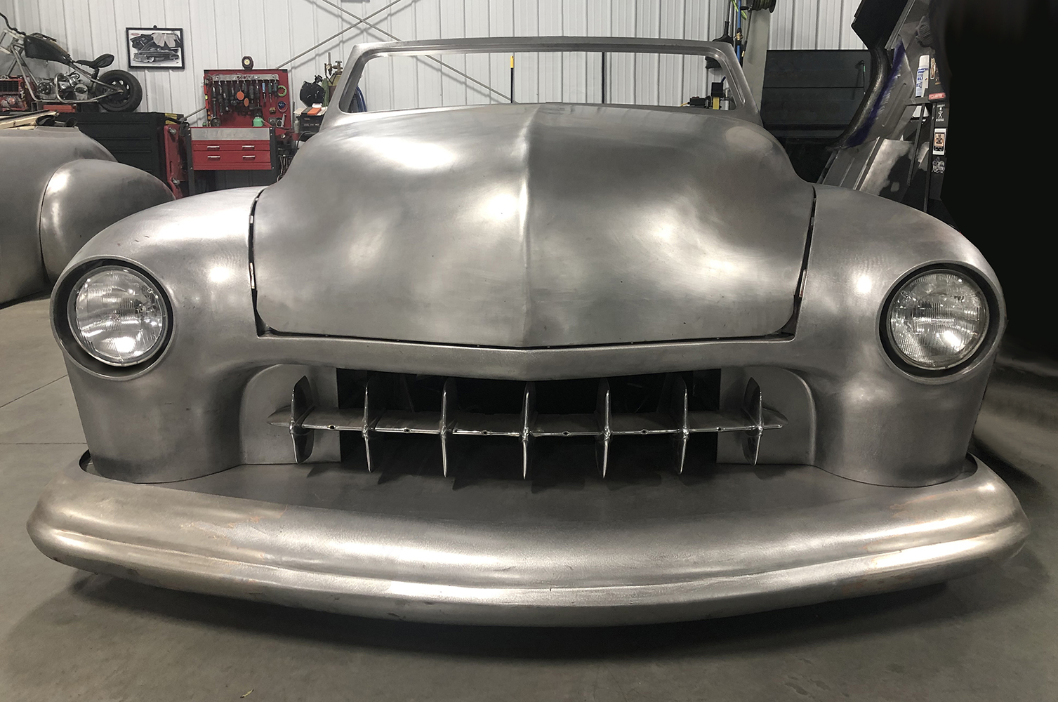 11 Fully installed headlight housings and grille on 1951 Mercury with raw metal body and custom details