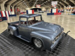 11 Gray 1956 Ford F 100 with polished wheels and red interior displayed on black checkered platform