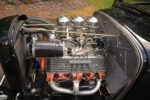2 1932 Ford engine bay showcasing vintage flathead V8 with finned valve covers and custom headers for clean hot rod style
