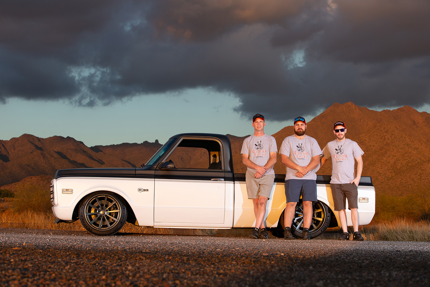 20 Three team members posed beside a 1969 Chevrolet C10 showcasing the truck’s profile and customization