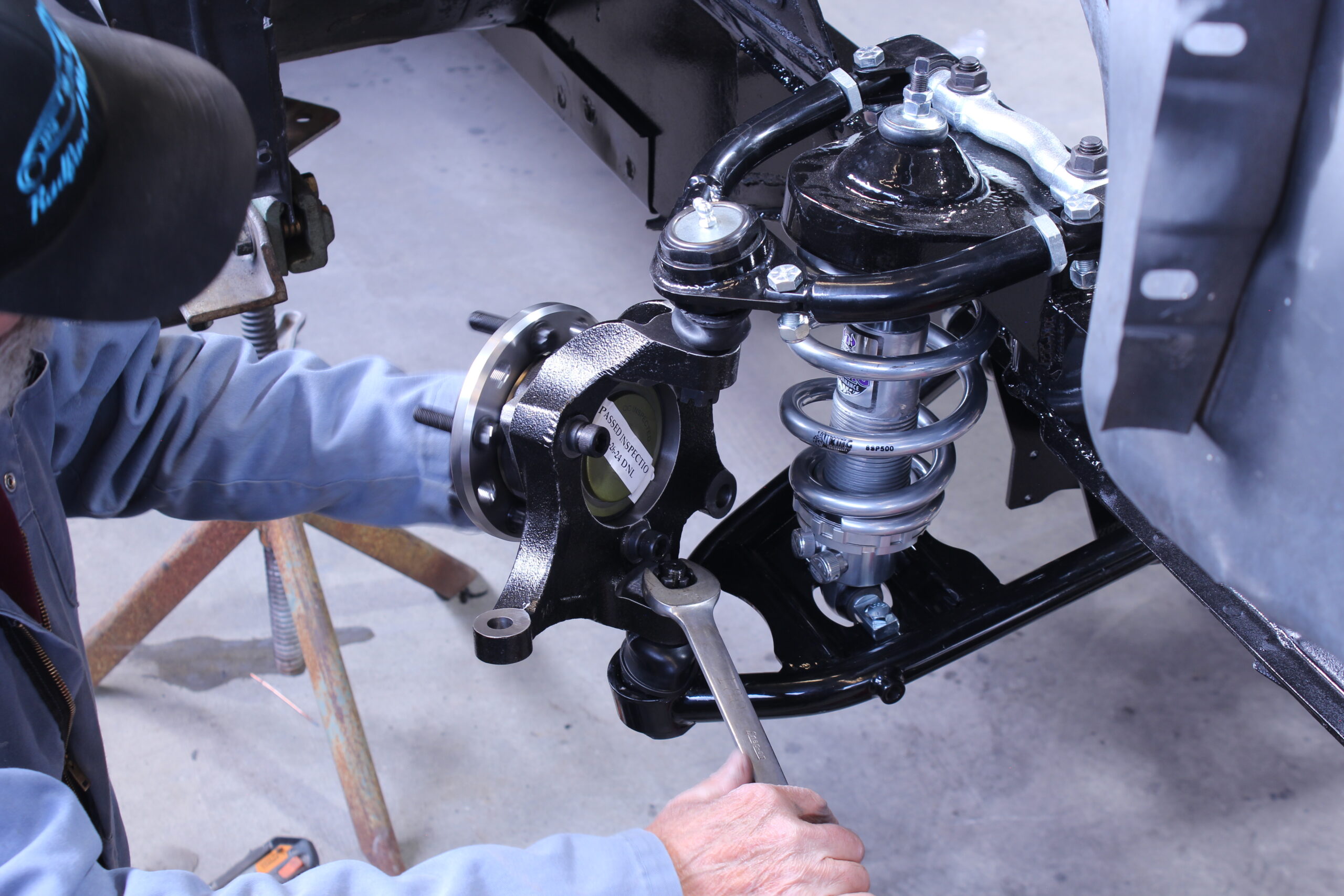 26 Technician installing the front hub assembly onto the 1965 Mustang s upgraded suspension system