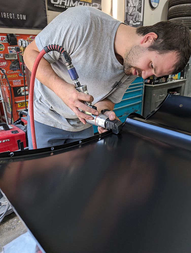 37 Technician grinding welds on 1966 Chevy truck door black outer skin edge