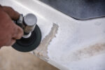 001 Sanding cracked fiberglass surface with a rotary tool to prepare for repair