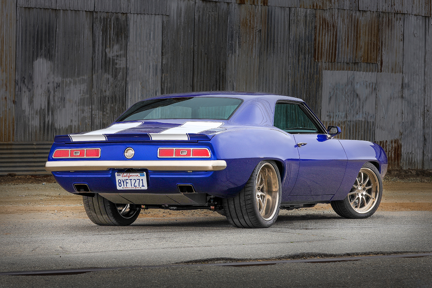 006 1969 Chevy Camaro rear angle blue paint white stripes and modern performance wheels