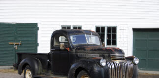 01 1946 Chevy Truck black patina pre restoration parked by a garage