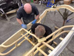 01 Fabrication specialists sanding and preparing a roadster chassis for finishing touches in a restoration shop