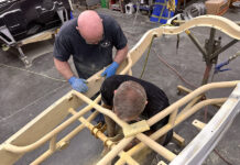 01 Fabrication specialists sanding and preparing a roadster chassis for finishing touches in a restoration shop