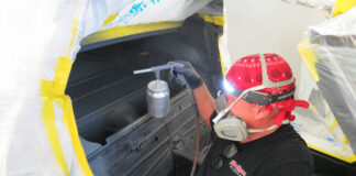 01 Technician applying advanced thermal acoustic coating inside a 1972 Corvette for enhanced heat and sound insulation