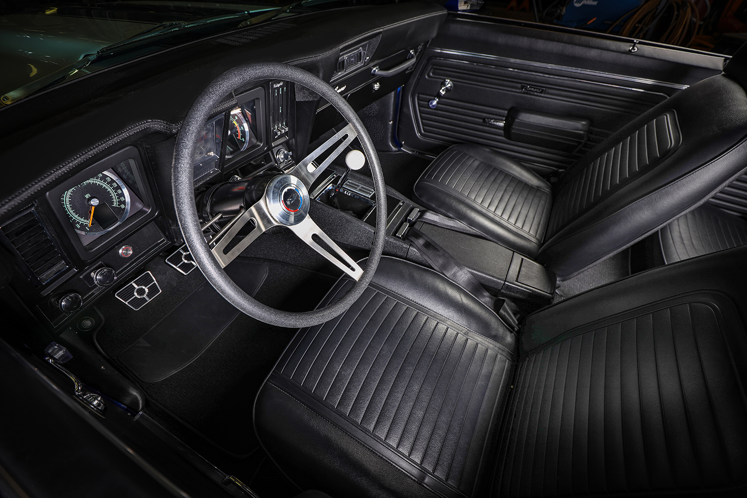 011 1969 Chevy Camaro interior with classic black upholstery and vintage steering wheel design