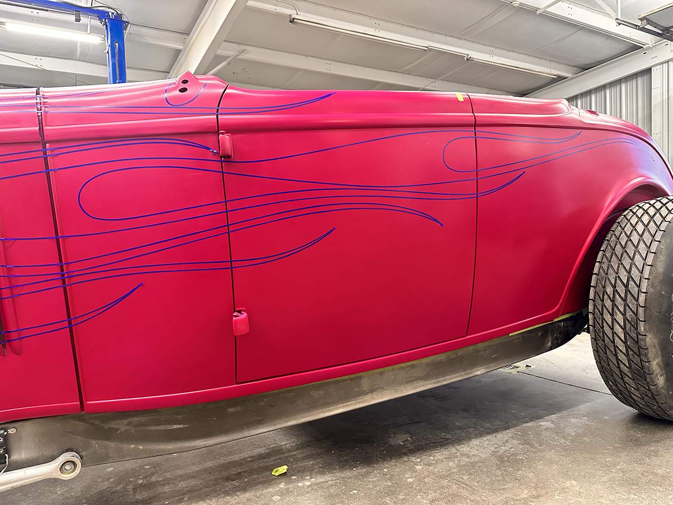 15 Close up of blue flame patterns drawn on the side of the roadster for a custom paint job