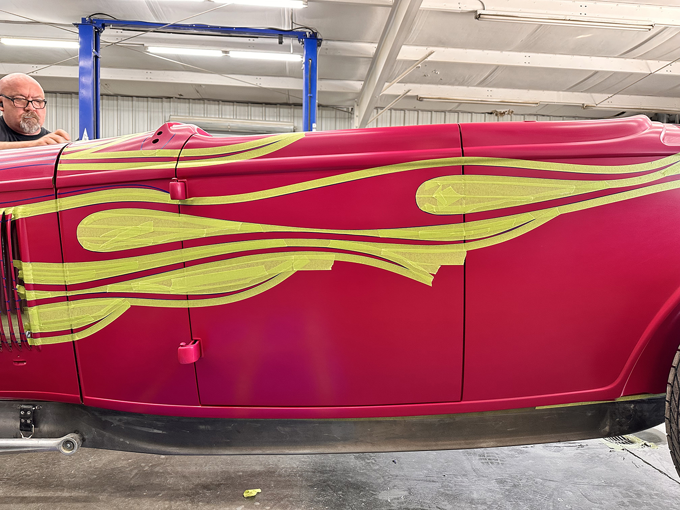 16 Yellow masking tape used to outline intricate flame designs on the roadster’s body