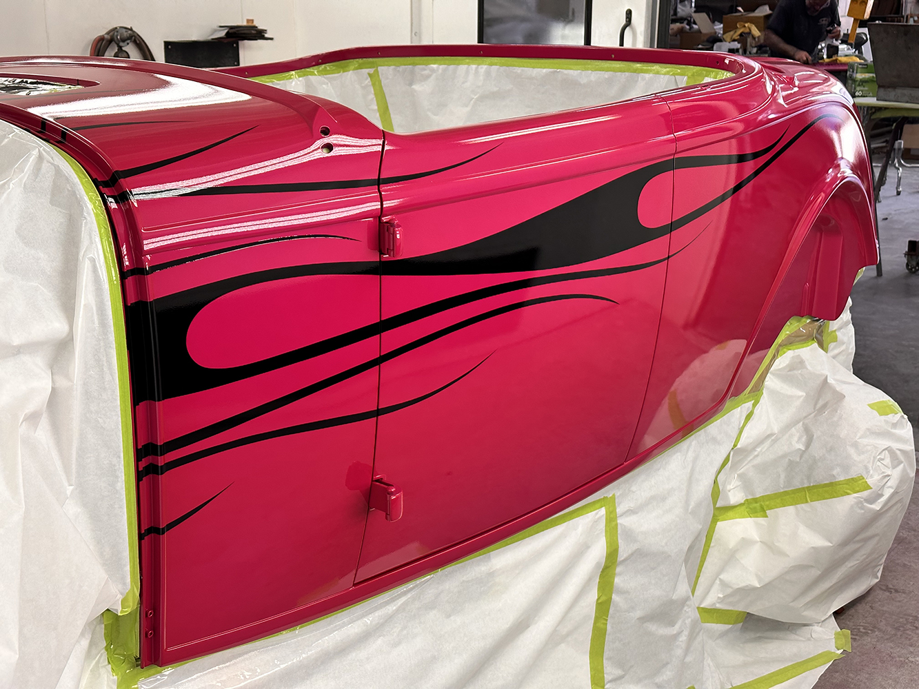 22 Side panel of the roadster showcasing a glossy black flame design over a vibrant pink base