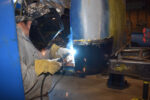 00 A fabricator welding a replacement cab corner on a classic truck