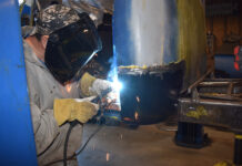 00 A fabricator welding a replacement cab corner on a classic truck