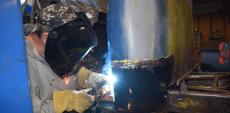 00 A fabricator welding a replacement cab corner on a classic truck
