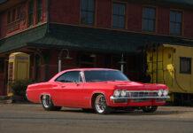 001 1965 Chevrolet Impala Super Sport red parked near a vintage train station custom wheels restored exterior