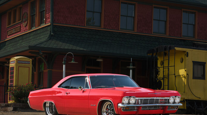 001 1965 Chevrolet Impala Super Sport red parked near a vintage train station custom wheels restored exterior
