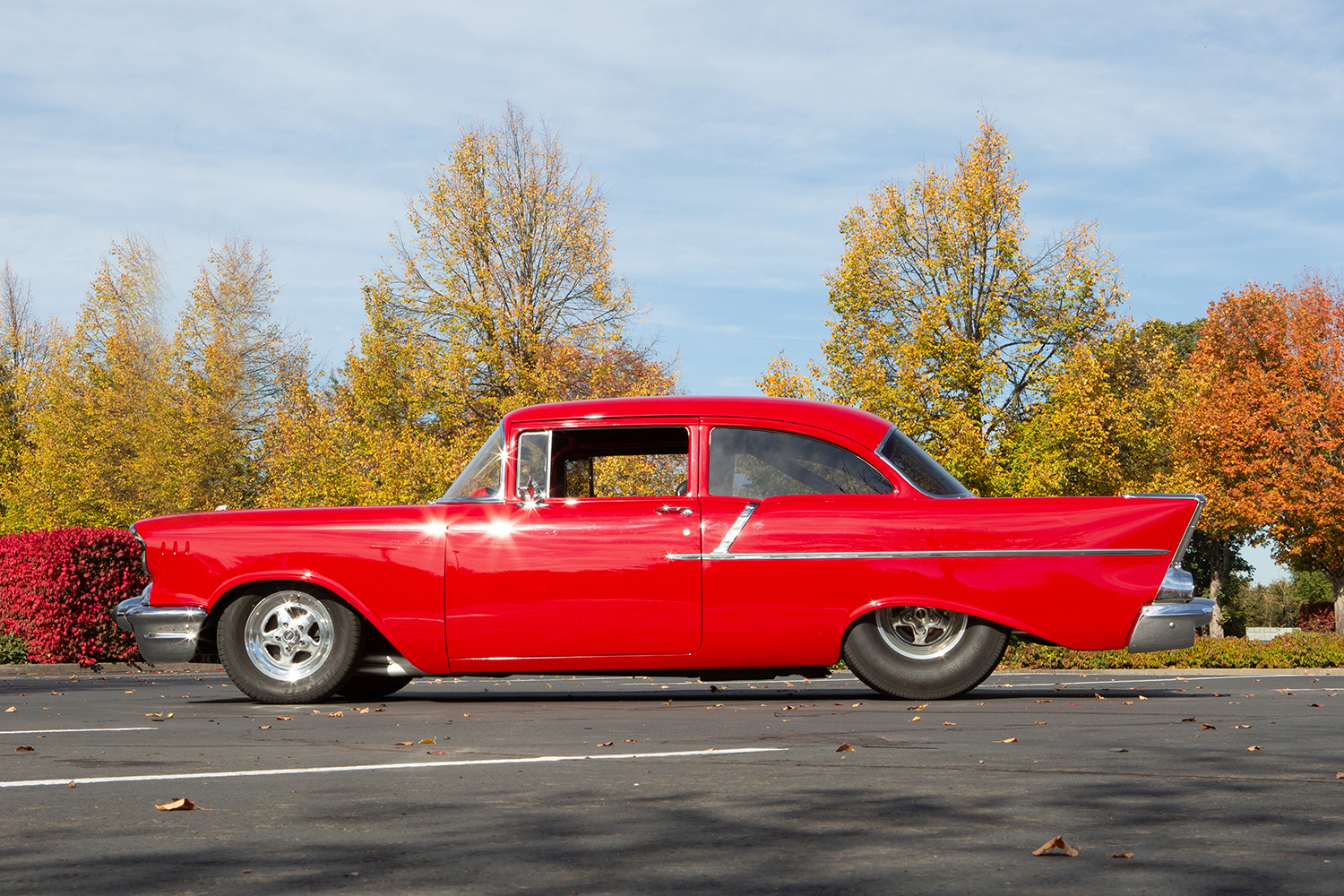 004 1957 Chevrolet Bel Air side profile showcasing bright red paint classic fins and a lowered hot rod stance
