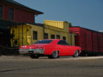 004 1965 Chevrolet Impala SS red rear three quarter view showcasing chrome bumpers dual exhaust and classic styling