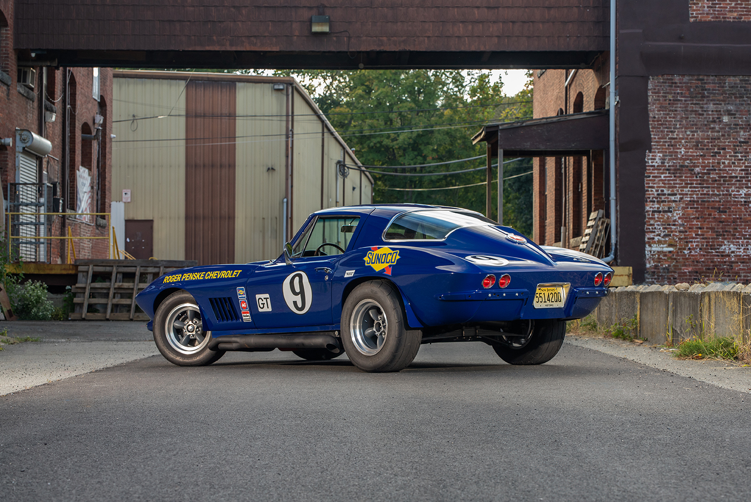 004 1966 Chevrolet Corvette blue rear three quarter view with chrome accents racing decals and dual exhausts