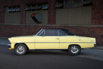 004 1967 Chevrolet Nova SS in yellow with black vinyl top chrome Cragar wheels parked by industrial brick walls
